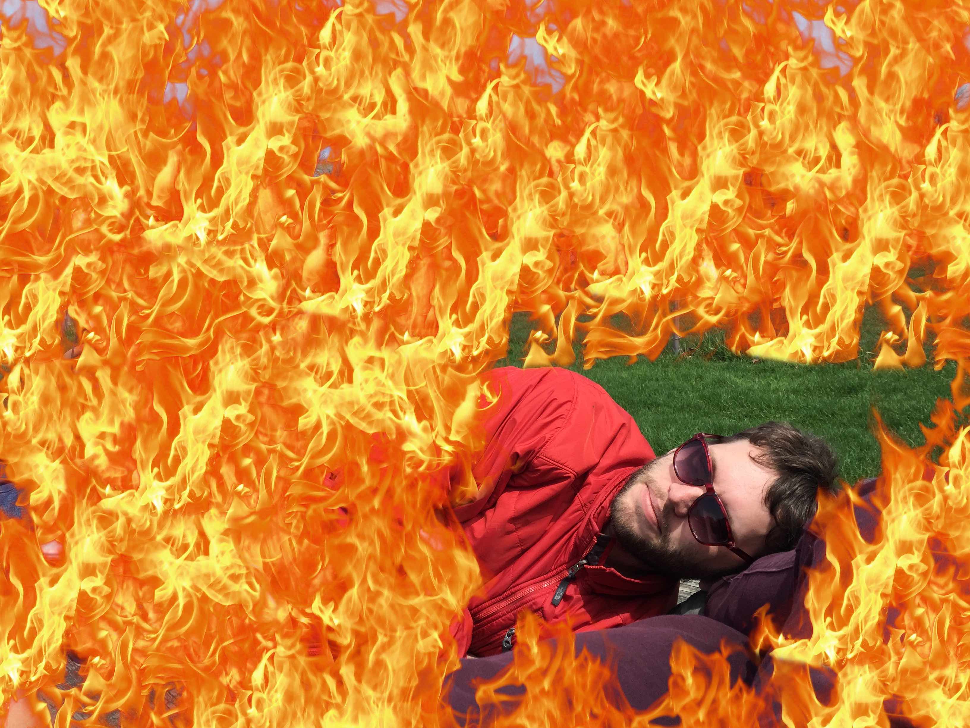 Tim Richardson lying down while surrounded by flames